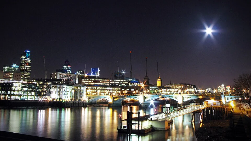 London at night from the Millennium Bridge with a full moon